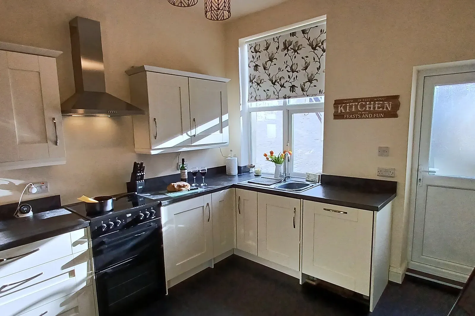 Bartley House kitchen with cream units, cooker and a window over the courtyard